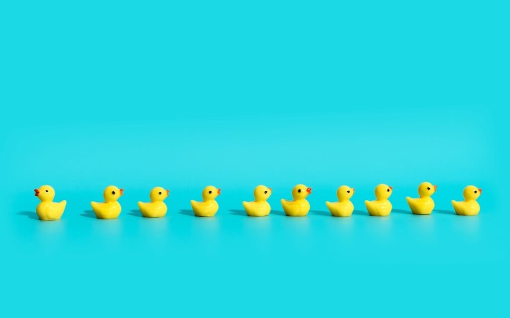 A line of yellow rubber ducks against a blue background